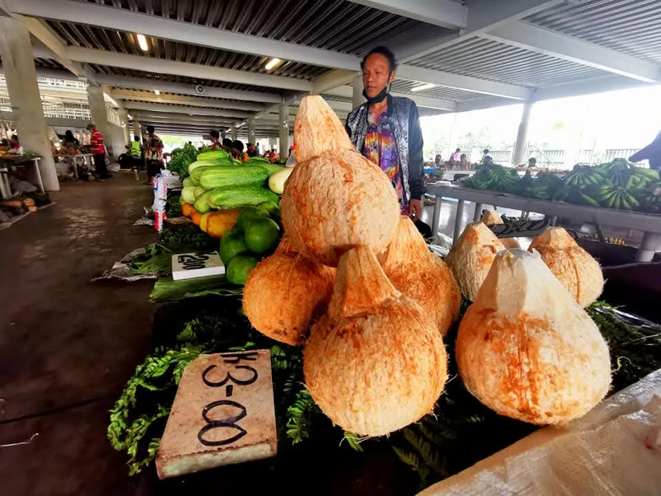 Husked coconuts for sale at a covered produce market